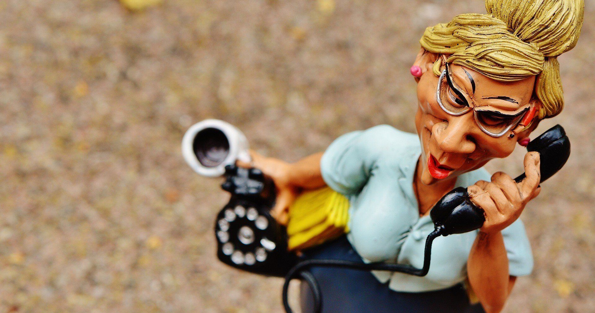 A figurine of a woman talking on a telephone.