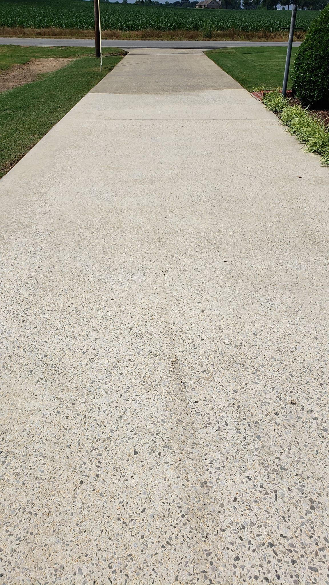 After Power Washing Driveway In Front of Field and Utility Pole | Harvest, AL | Radiant Exterior Cleaning