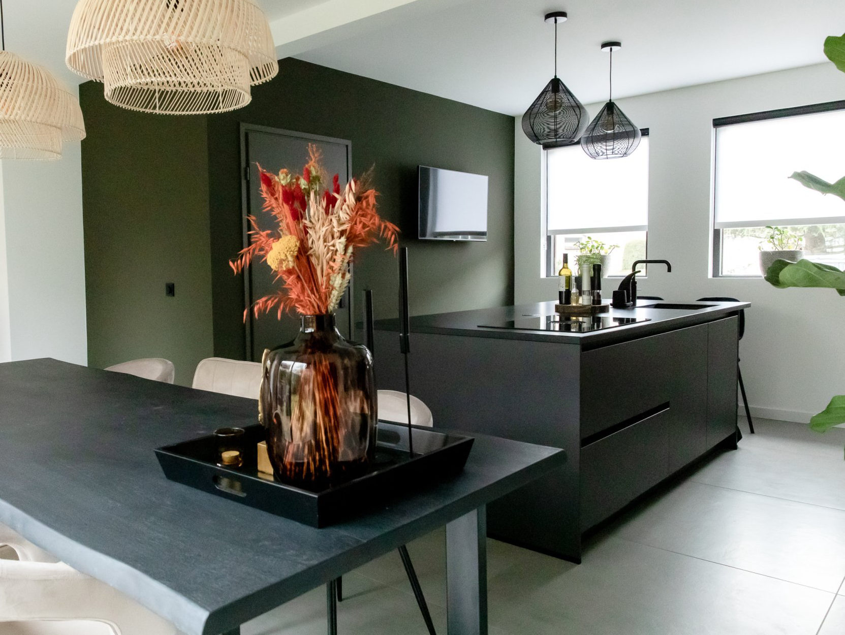 Vide in de woonkamer. Zwart keukeneiland en natuurlijke materialen in open keuken.