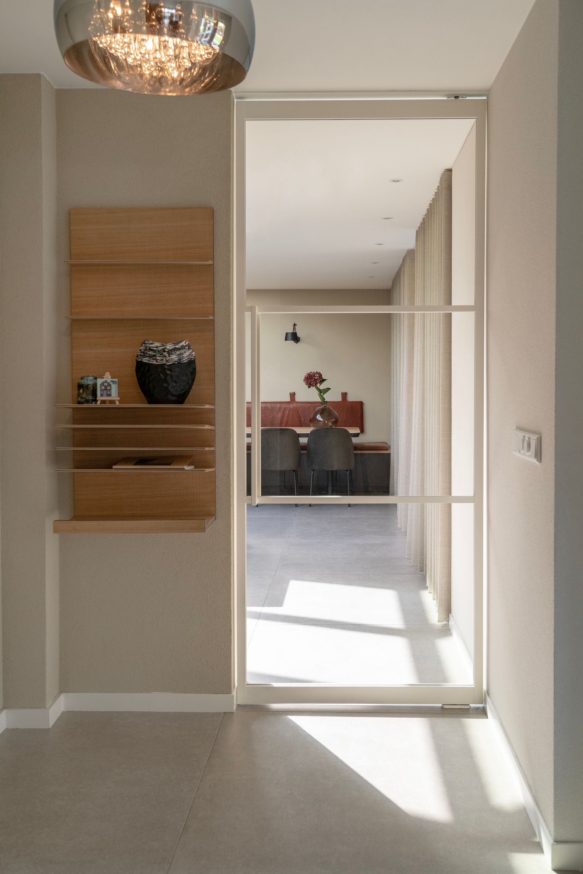 De witte stalen taatsdeur vormt de verbinding tussen de woonkamer en de keuken.
