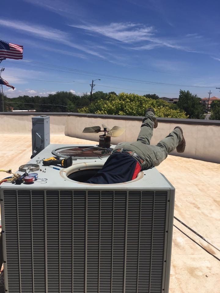 Serv Tech Pro worker servicing an industrial rooftop HVAC unit 
