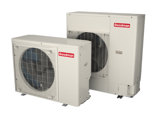 Two Goodman-branded beige outdoor HVAC heat pump units of different sizes, positioned side-by-side against a white background.