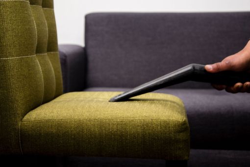Deep-clean carpet service with vacuum in a bright living room, plus green eco-friendly text and icons