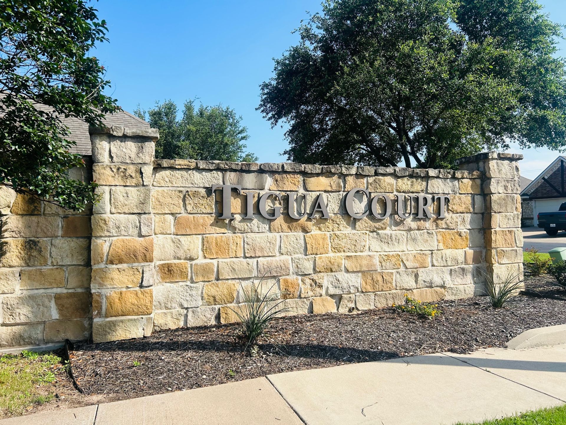 A brick wall with the words tigua court written on it