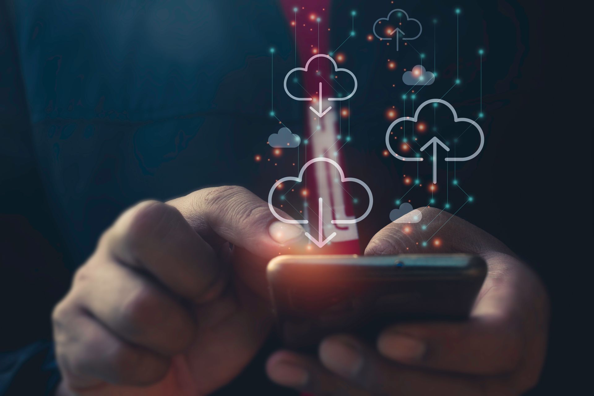Hands using a smartphone with glowing cloud download icons above it