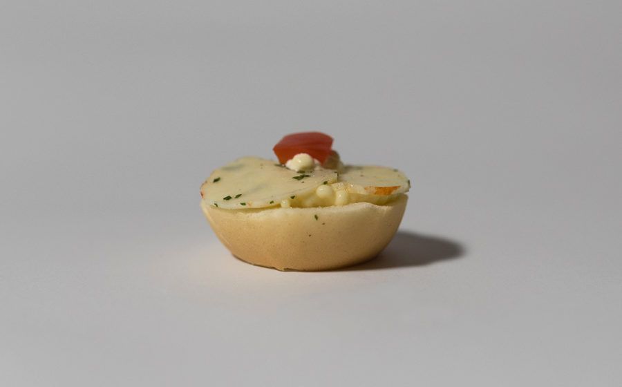 Antipasto: Biscotto ripieno di purè di patate, guarnito con pomodoro e panna.