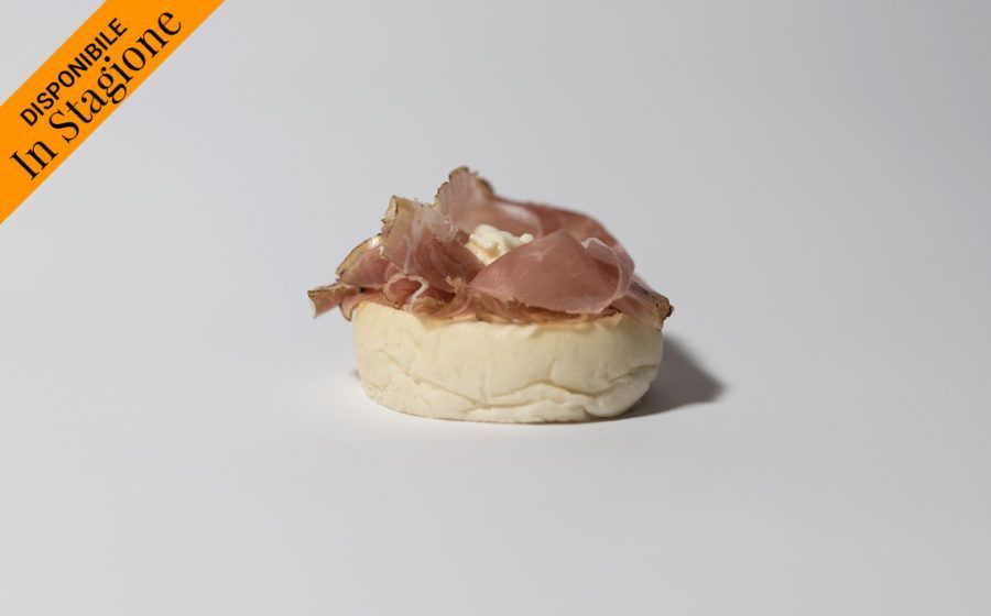 Un piccolo antipasto con prosciutto su pane bianco, con l'etichetta 