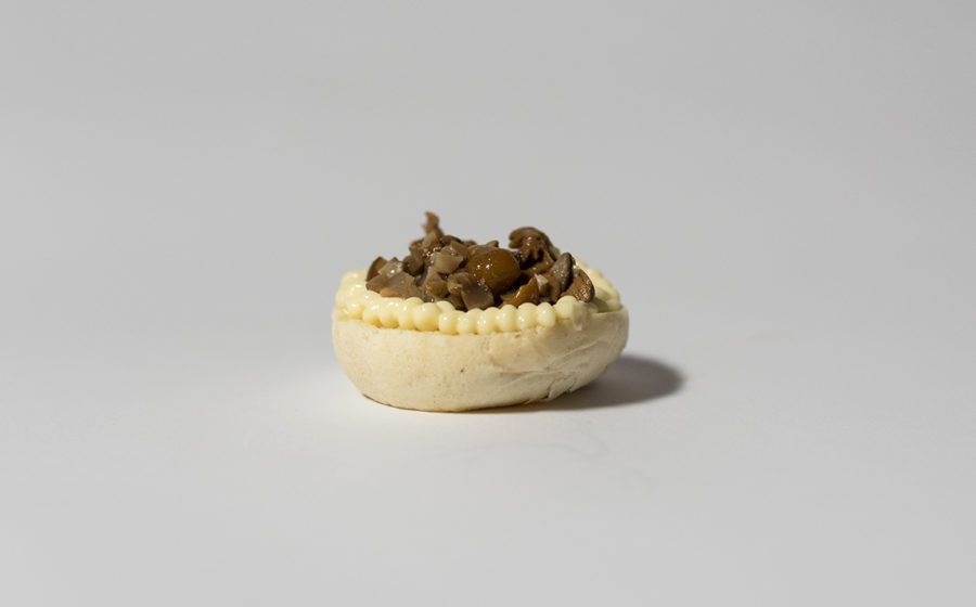 Mini guscio di pasta sfoglia ripieno di carne marrone.