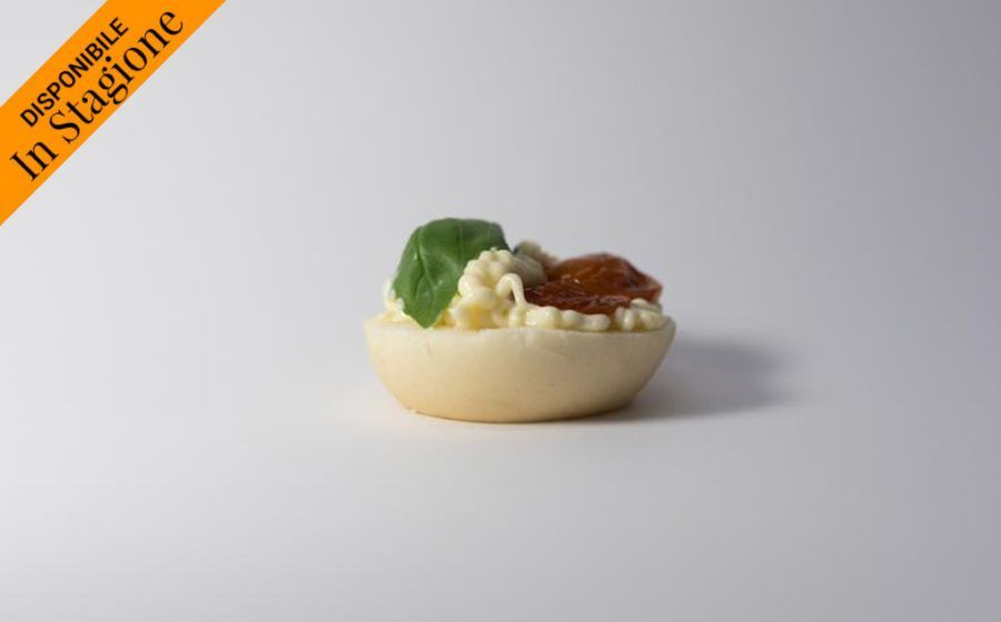 Un unico guscio di pasta sfoglia ripieno di crema, guarnito con una foglia e frutta secca, con la scritta 