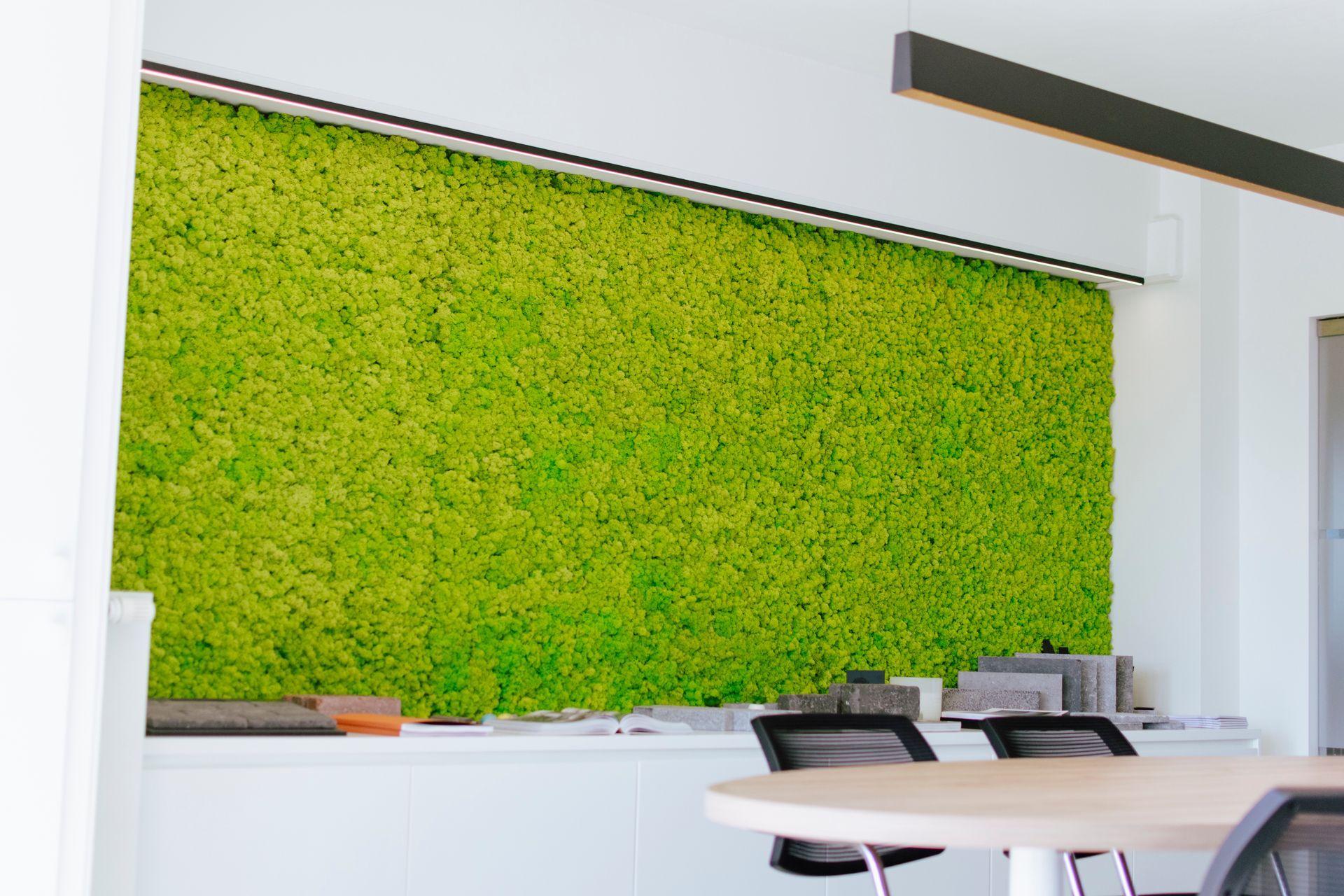 Mur végétal vert vif dans une salle de conférence de bureau moderne avec une table et des chaises