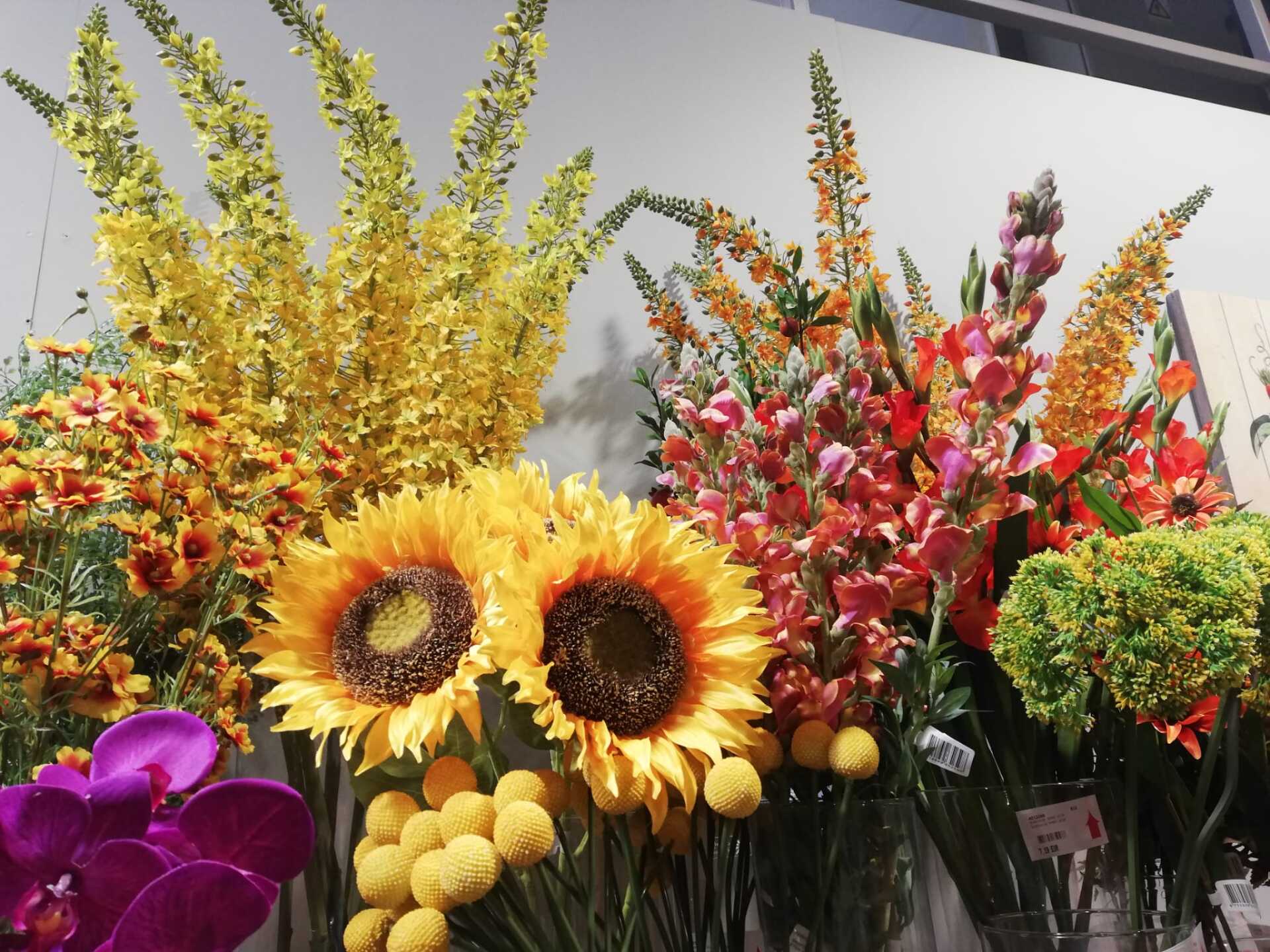 Bright bouquet of sunflowers, red and yellow flowers, and purple blooms in a flower market