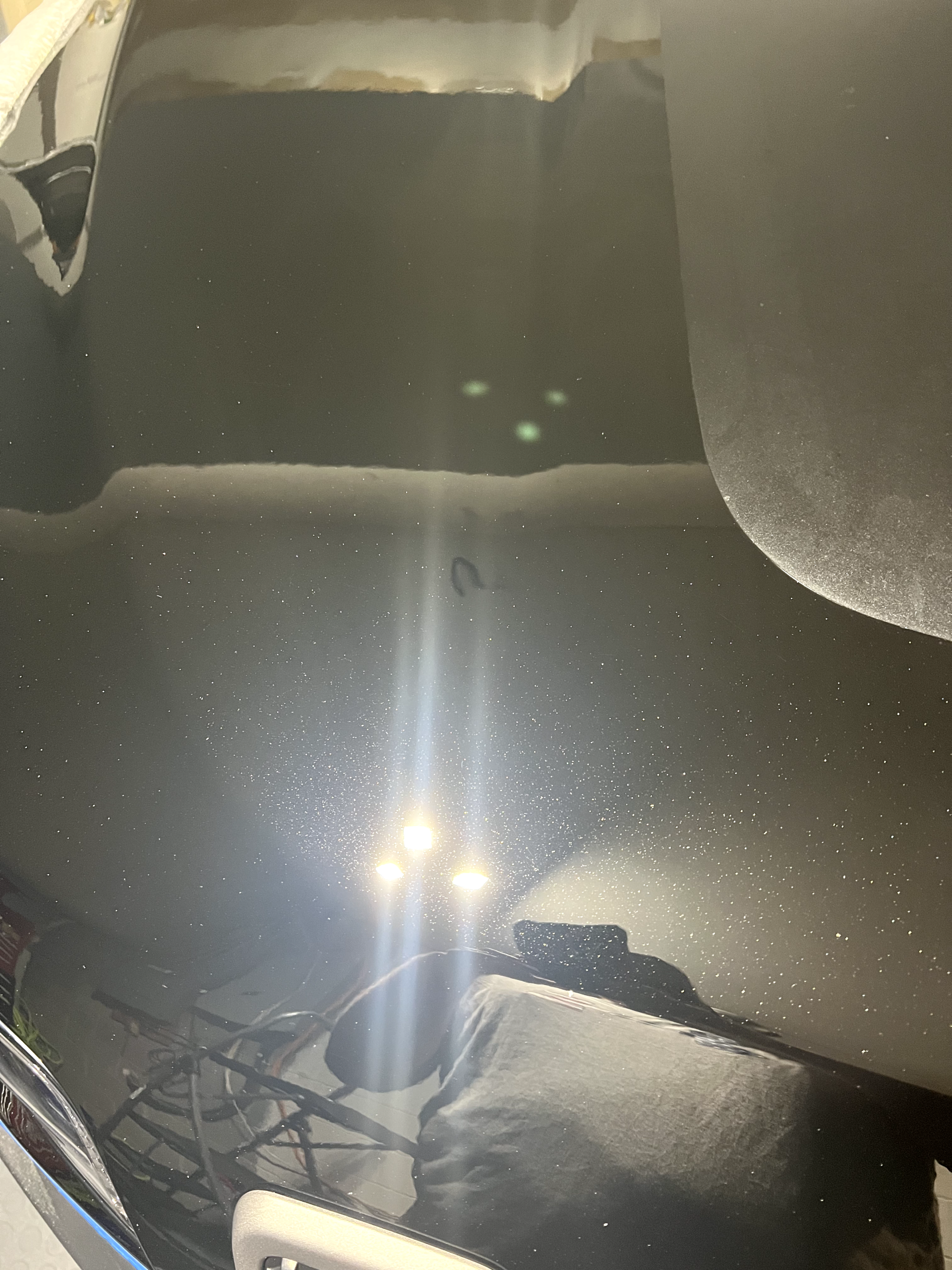 a close up of a car hood with a light shining through it