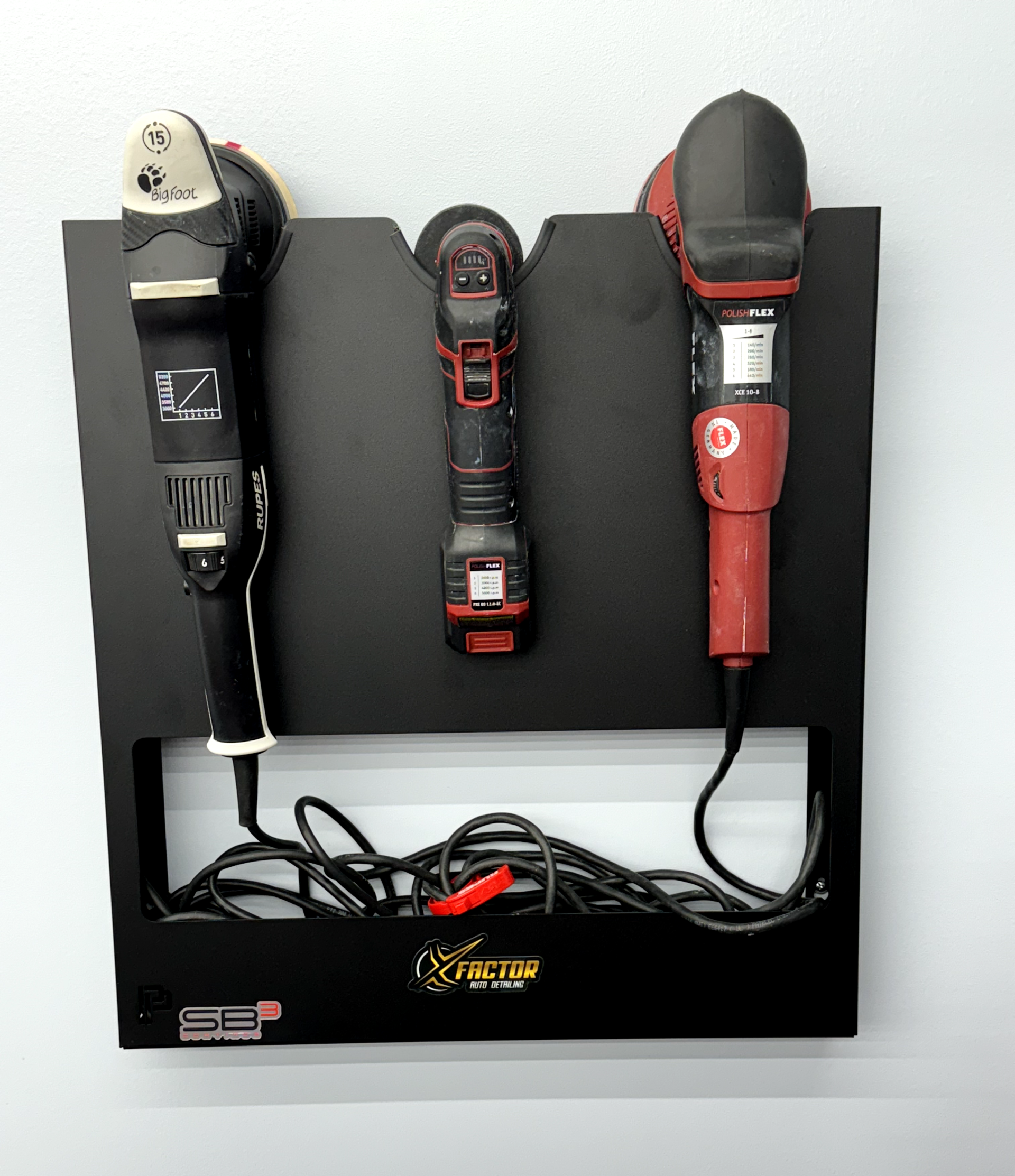 three polishing machines are sitting on a black shelf .