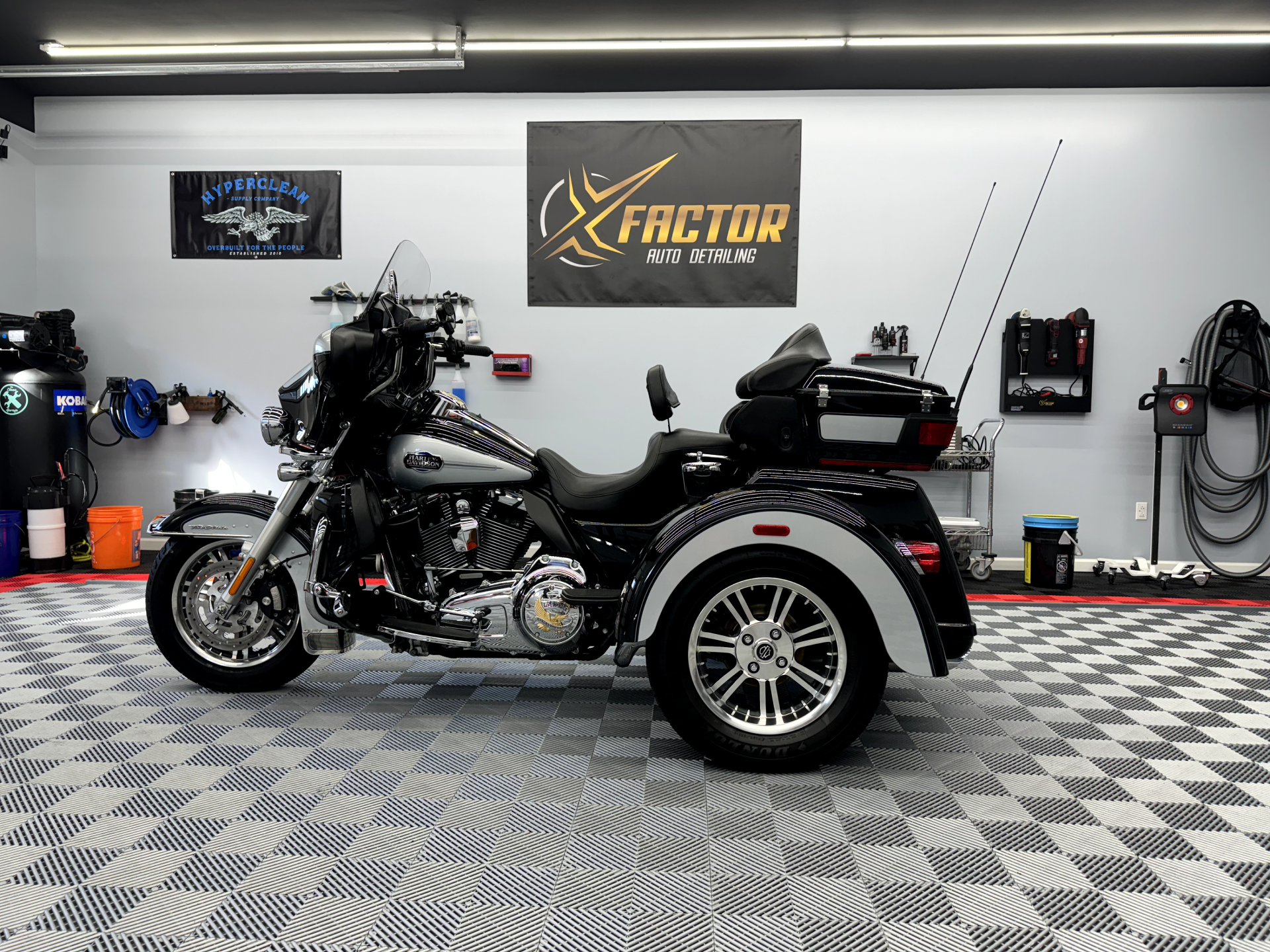 a motorcycle with three wheels is parked in a garage .