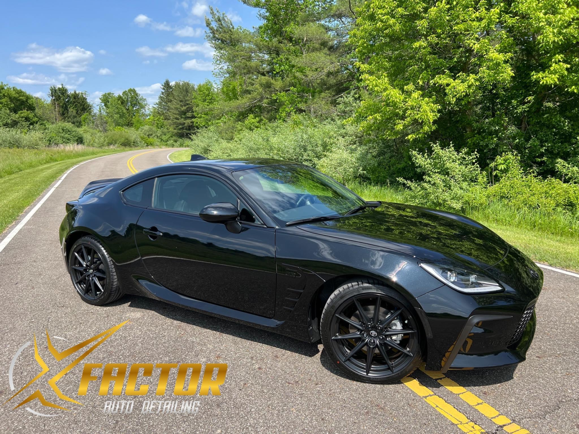 a black sports car is parked on the side of a road .