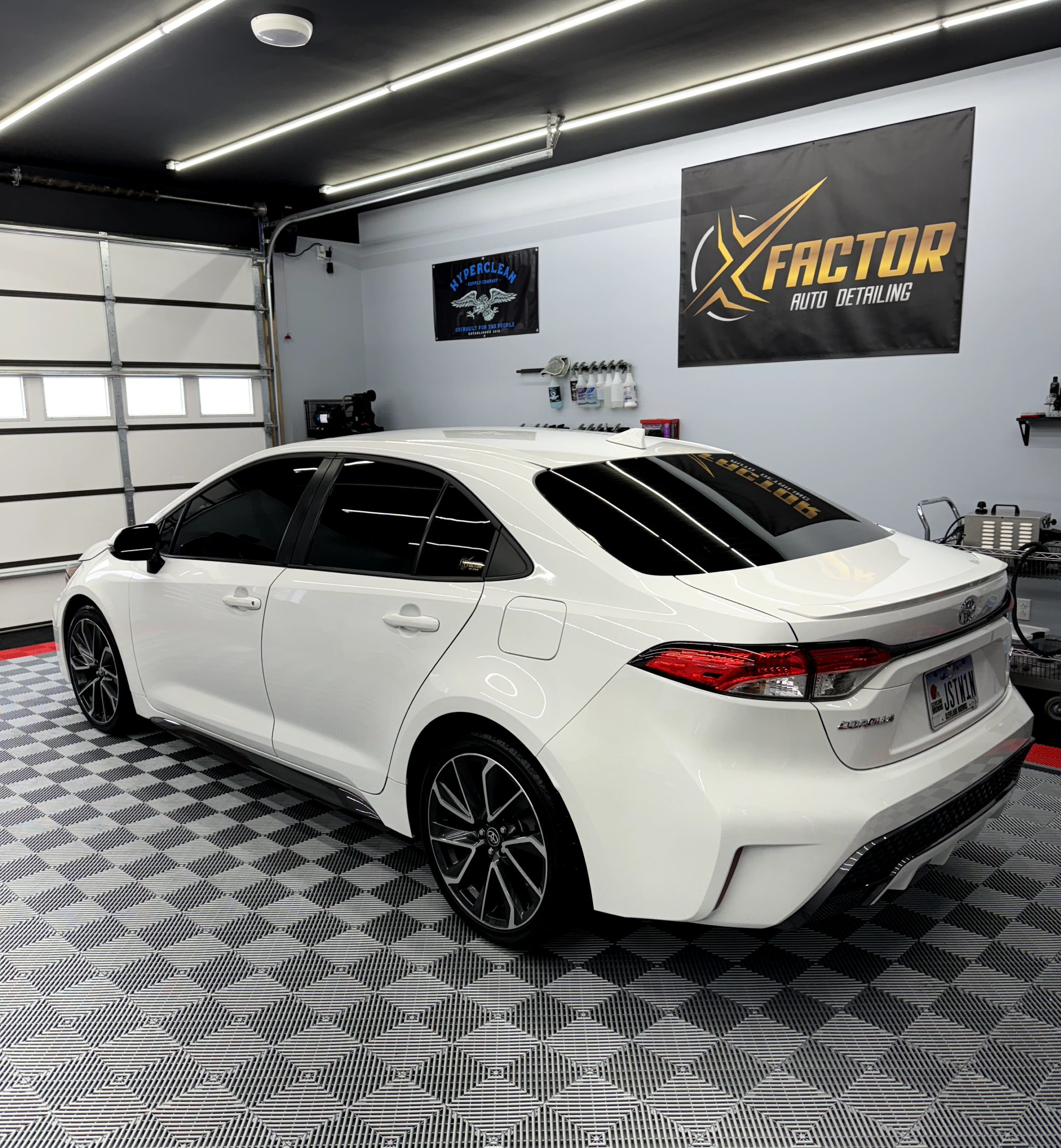 a white car is parked in a garage next to a sign that says factor
