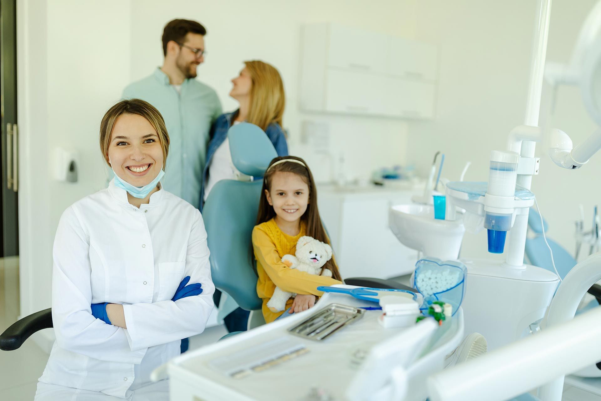 A family dentist providing care for a child during a dental visit. A family dentist providing care for a child during a dental visit.