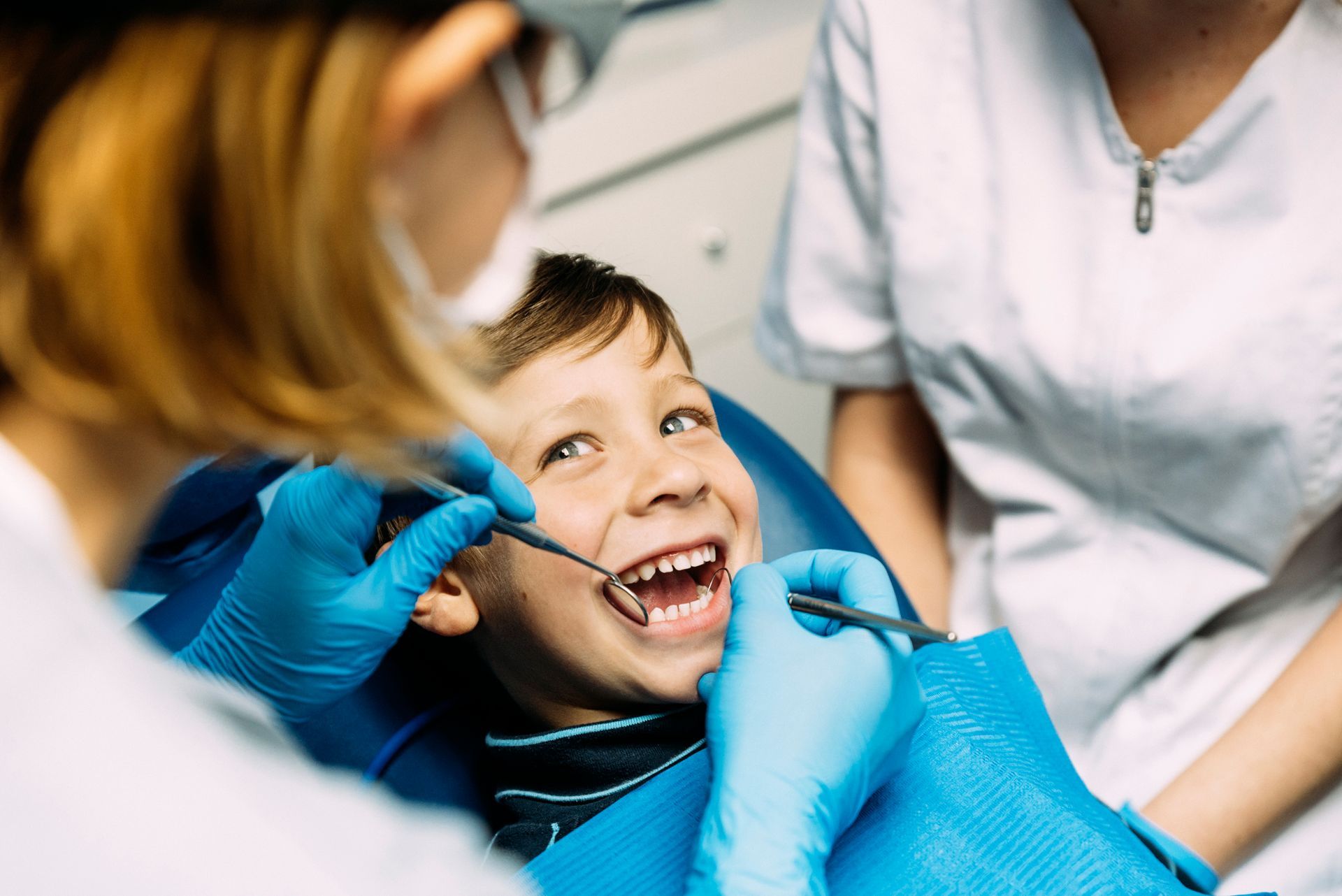 A young boy is getting his teeth examined by a dentist.