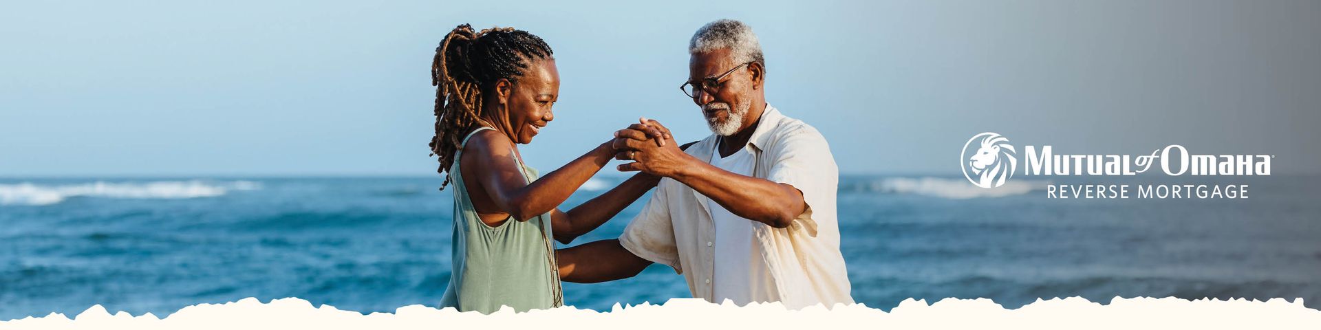 Two people clasp hands on a sunny beach with turquoise ocean waves and resort branding in the background.