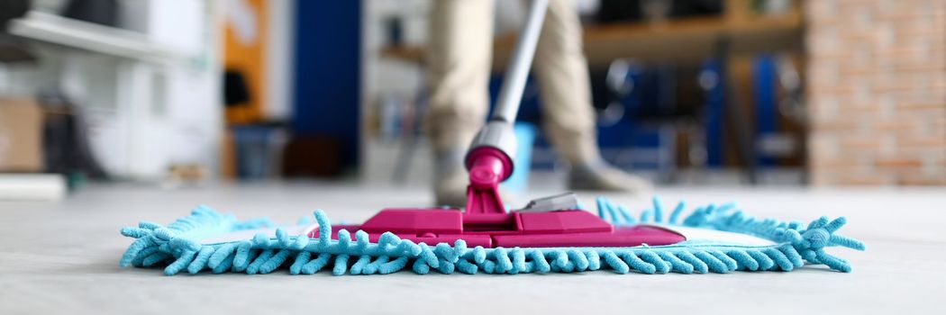 Pink mop head cleaning a shiny floor with blue dust strands in a room Pink mop head cleaning a shiny floor with blue dust strands in a room