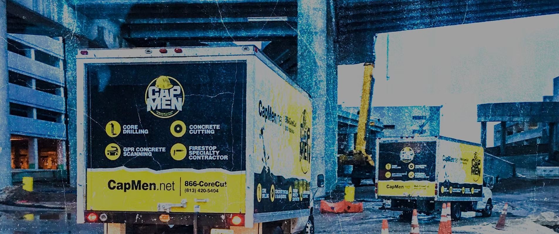 Yellow delivery trucks under a highway overpass, including a large CapLife truck in the foreground.