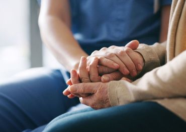 A nurse is holding the hands of an elderly woman. A nurse is holding the hands of an elderly woman.