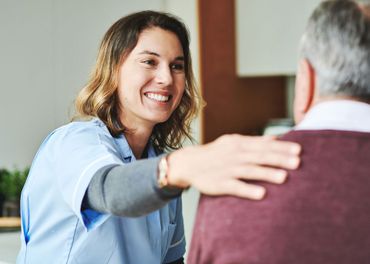 A nurse is hugging an elderly man and smiling. A nurse is hugging an elderly man and smiling.
