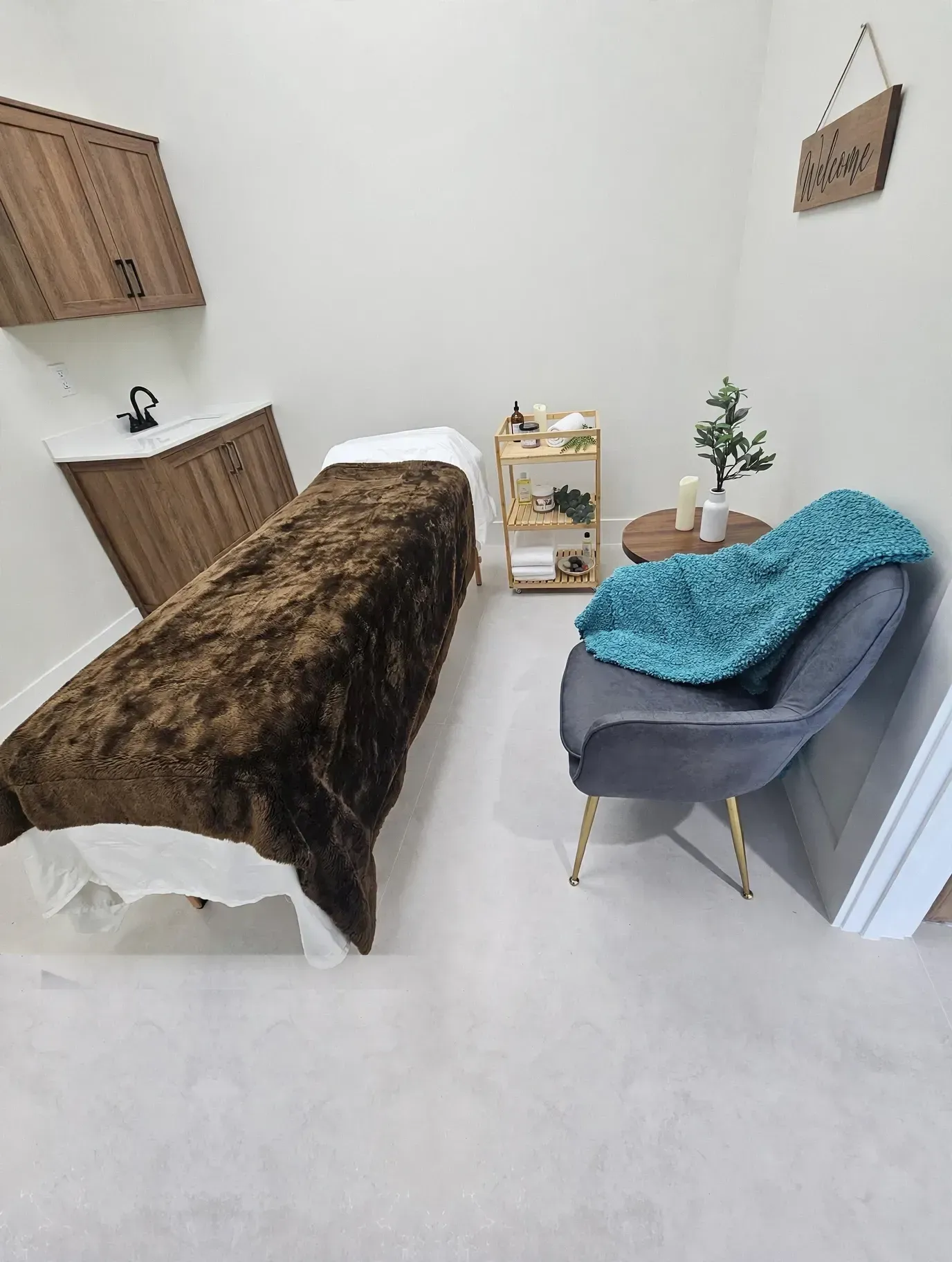 Modern black-and-gray spa room with treatment chair, manicure table, and framed wall art