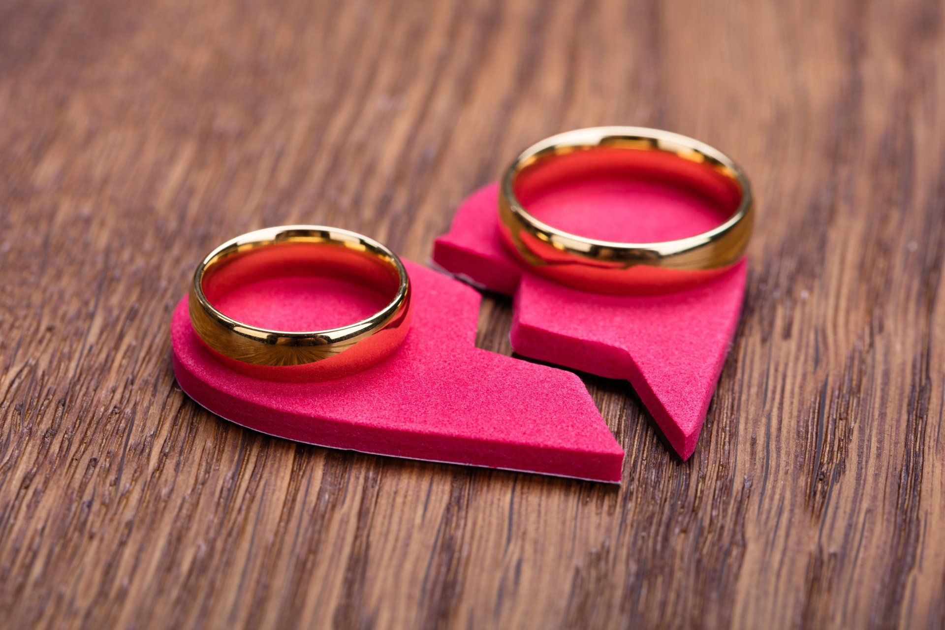 Bright Pink broken heart with a wedding ring on each half.
