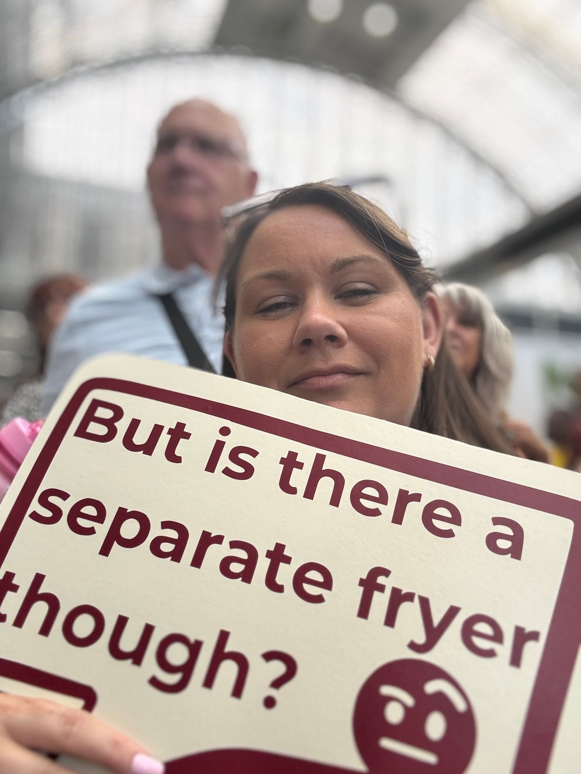 Victoria-jayne has long brown hair and is holding as cream sign with red writing.