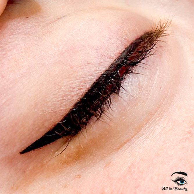 Close-up of a person's closed eye with a sharp, black eyeliner wing on the eyelid.