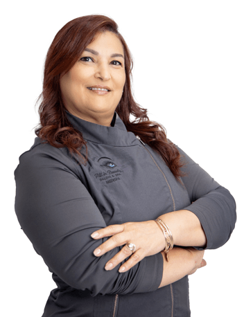 Woman with auburn hair in a gray zip-up jacket, arms crossed, smiling.