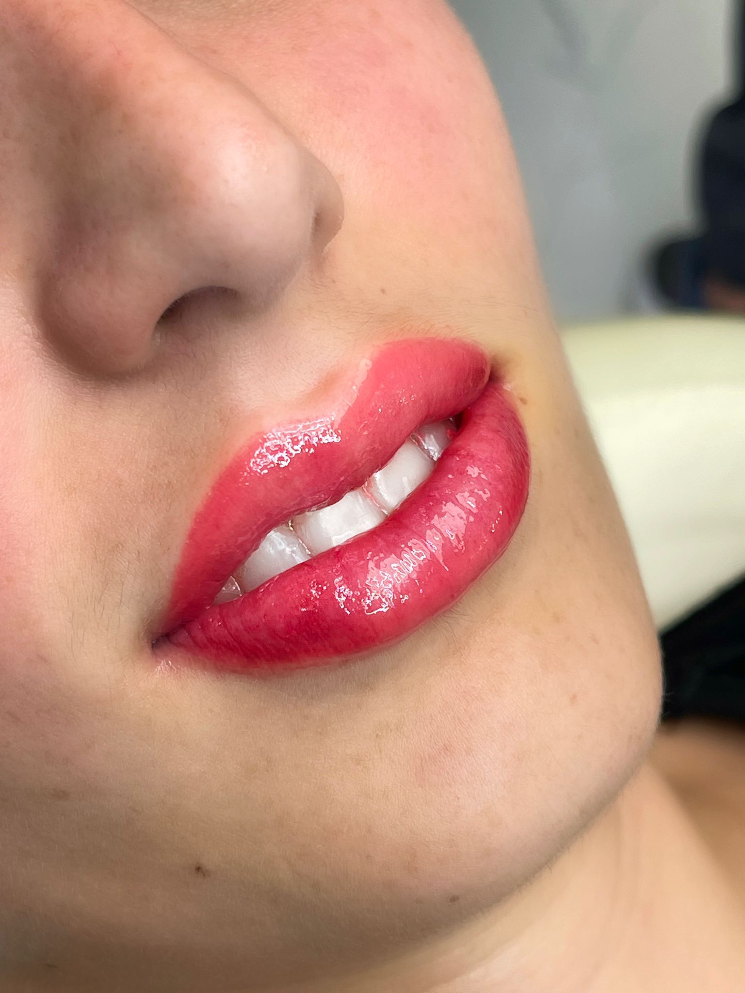 Close-up of a person's lips with bright pink lipstick. The skin is light.