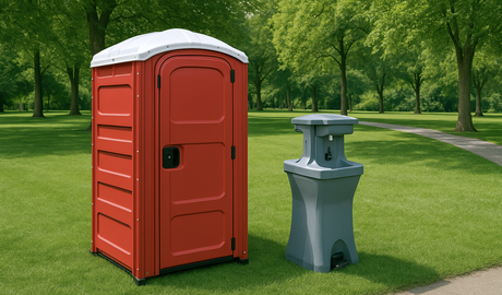 A red portable toilet is sitting on top of a lush green field.