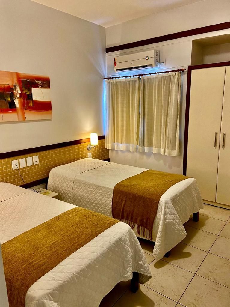 Um quarto de hotel com duas camas e um quadro na parede.