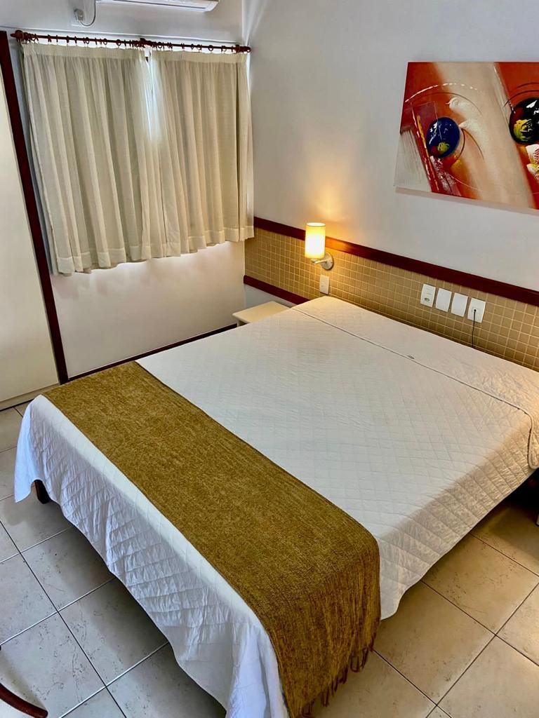 Um quarto de hotel com uma cama e um quadro na parede.