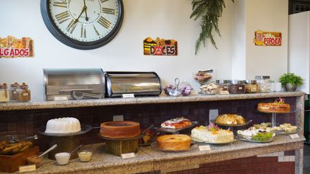 Uma mesa coberta com uma variedade de sobremesas, incluindo bolo e cupcakes.