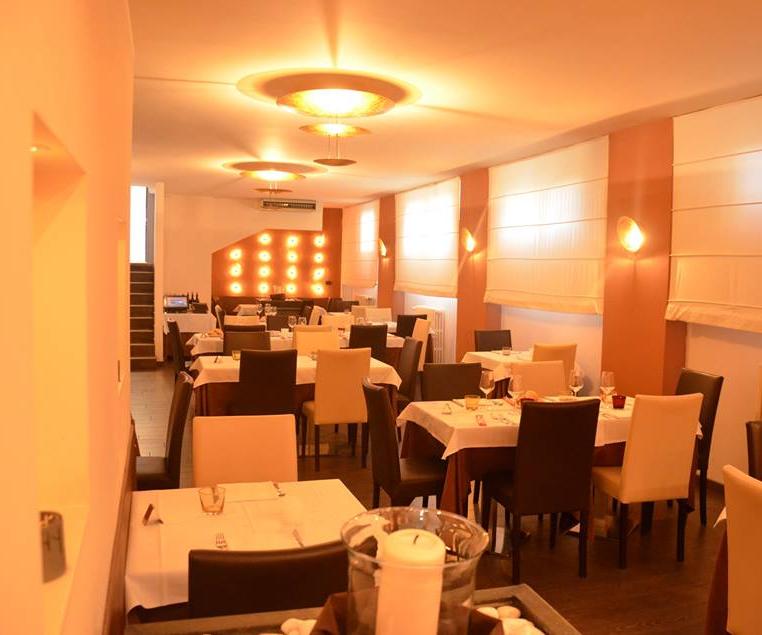 Una sala da pranzo con tavoli e sedie e una candela al centro