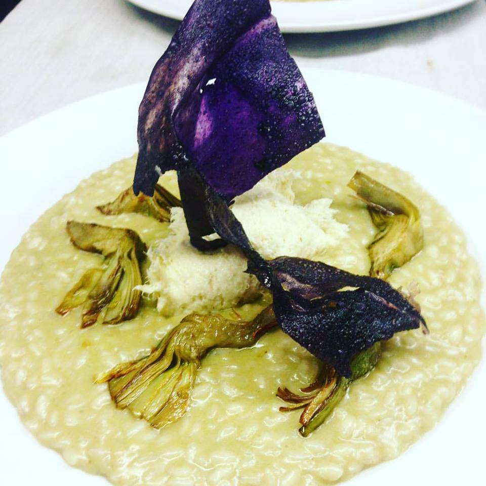 Un primo piano di un piatto di cibo con carciofi e formaggio
