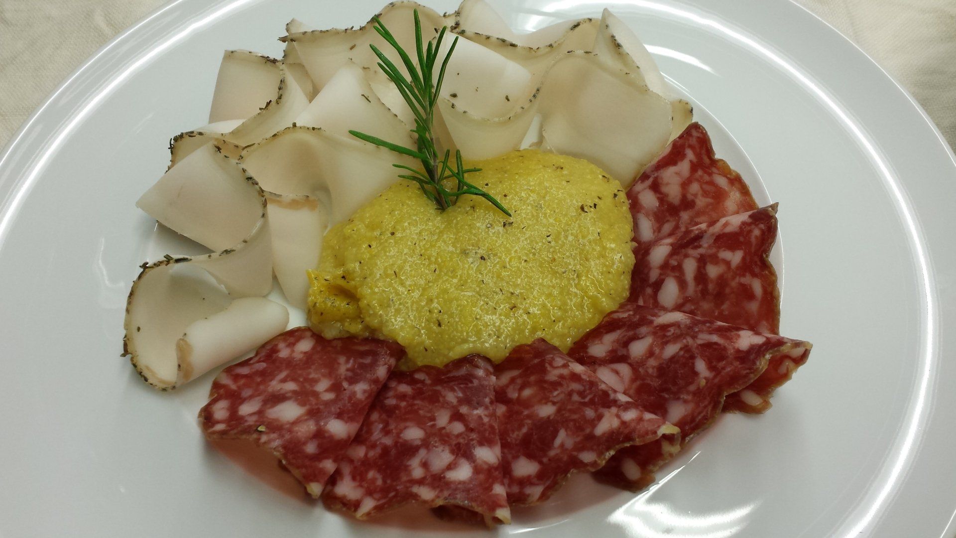 Un piatto bianco con sopra carne e salsa su un tavolo.