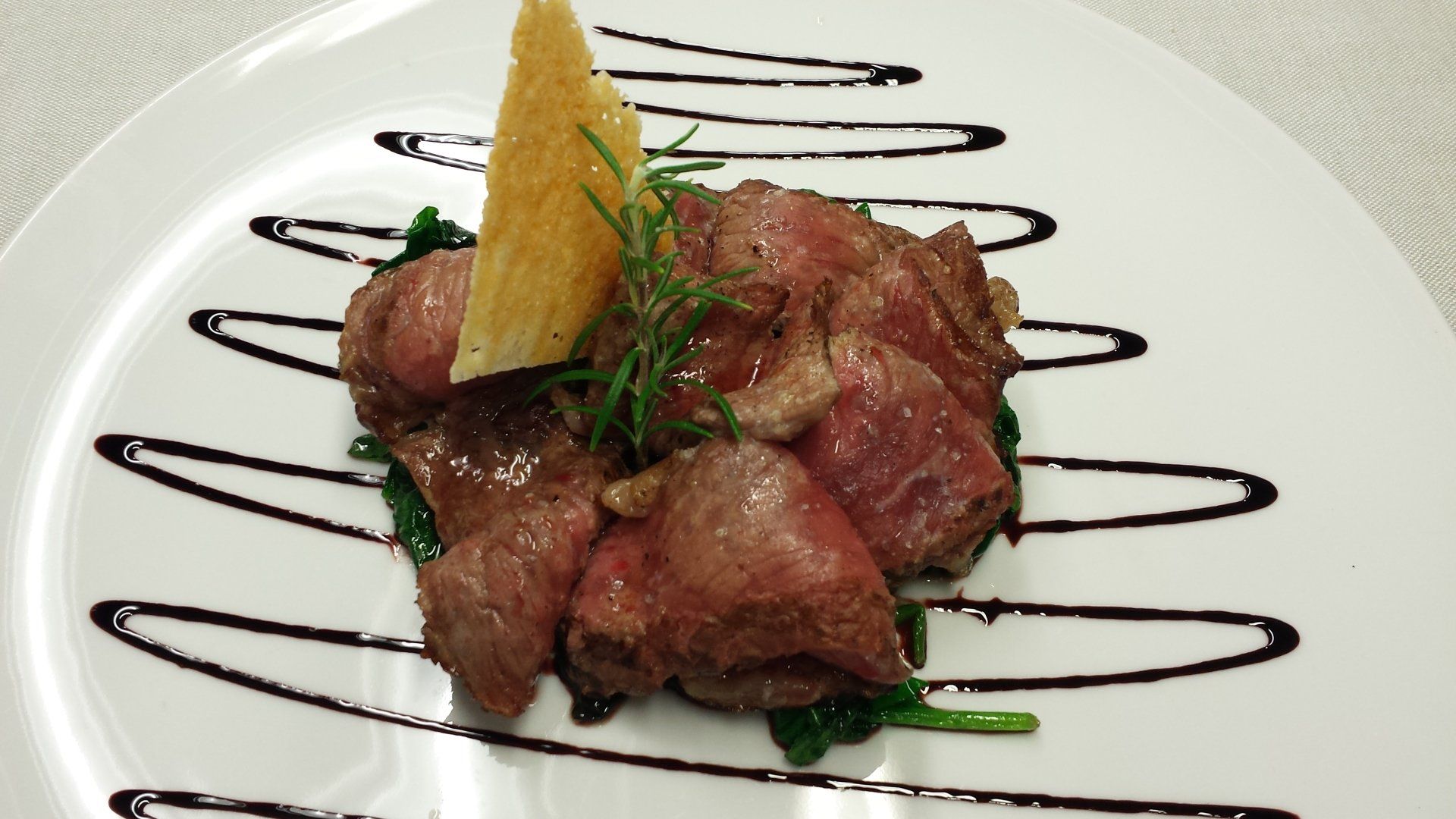 Un piatto bianco con sopra carne e una fetta di limone
