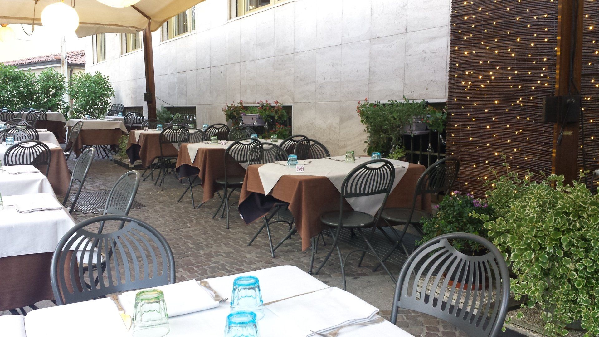 Un ristorante con tavoli, sedie e bicchieri sopra