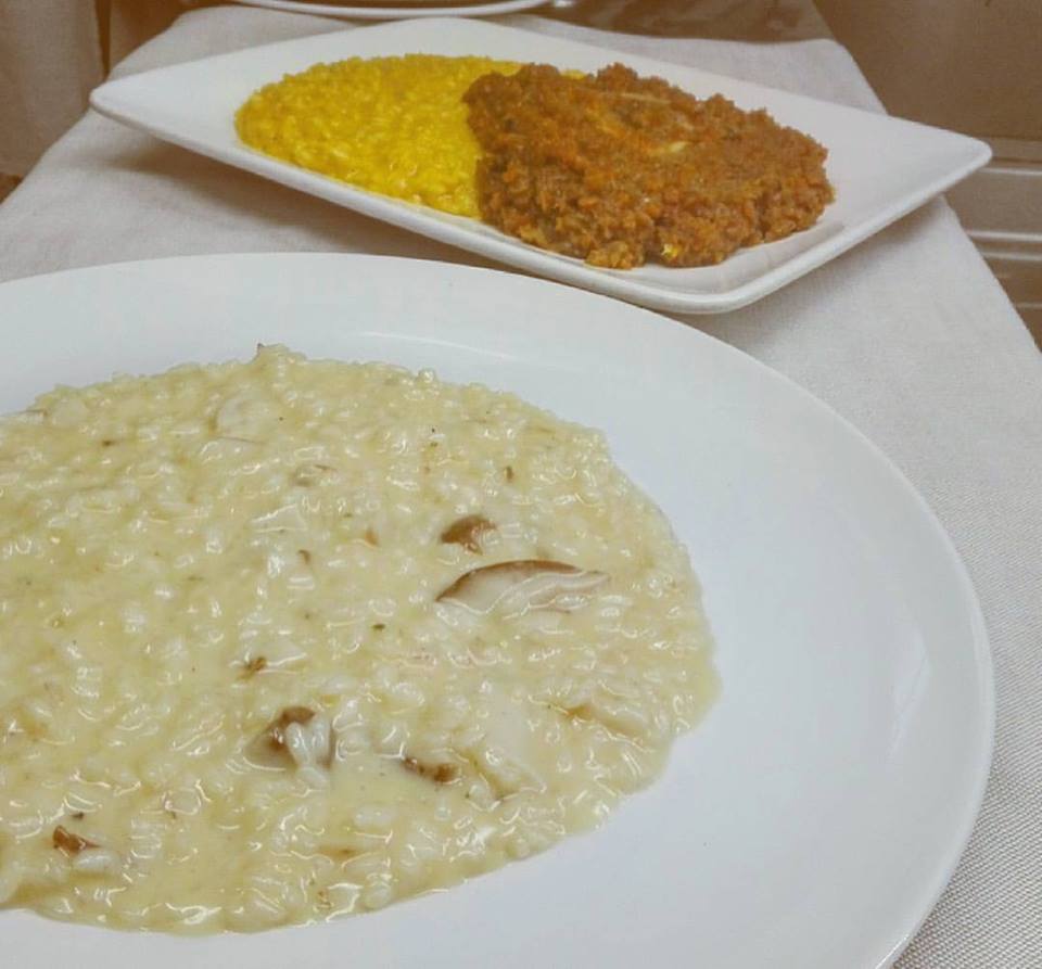 Due piatti di cibo su un tavolo uno dei quali è risotto