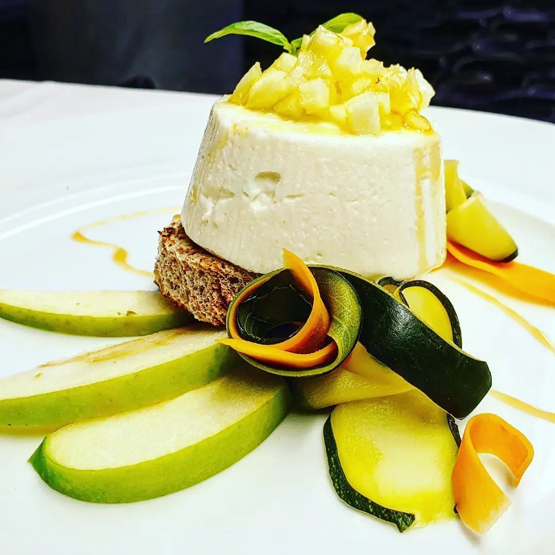 Un piatto bianco guarnito con fette di mele e zucchine