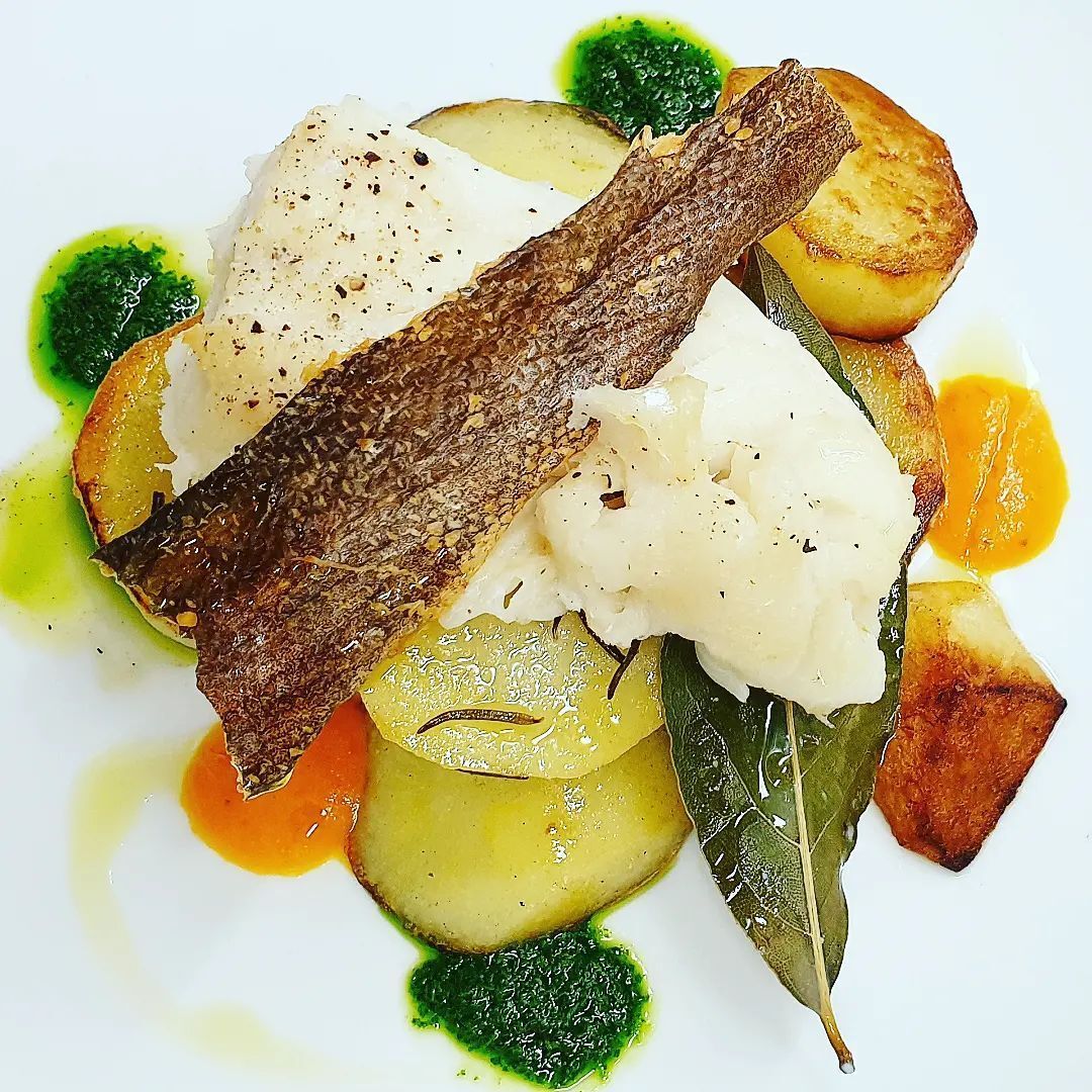 Un piatto bianco condito con purè di patate, carne e verdure.