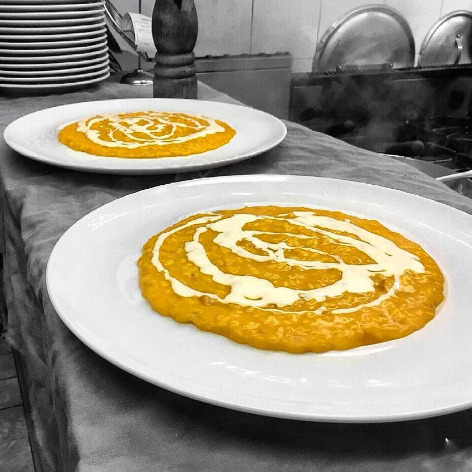 Due piatti di cibo su un tavolo, uno dei quali ha un ricciolo di crema sopra