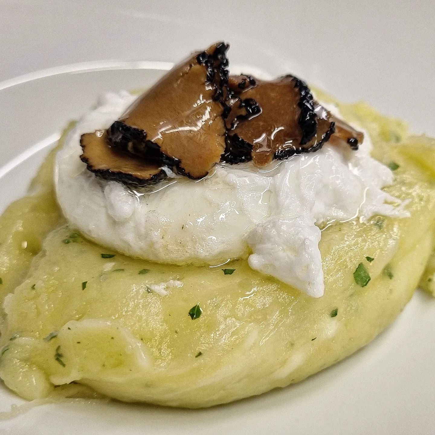 Un piatto bianco condito con purè di patate e panna montata