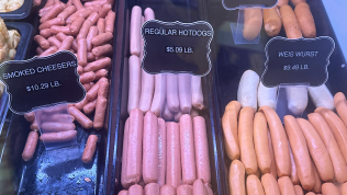 A display case filled with different types of hot dogs.