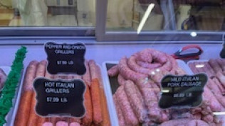 A display case filled with sausages and carrots in a butcher shop.
