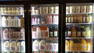 A refrigerator filled with lots of different types of milk and juices.